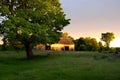 Old Country Abandoned Barn With Sunset and Large Tree Royalty Free Stock Photo