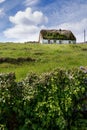 Old country house in a field on a warm sunny day, blue sky. Inishmore, Aran Islands, County Galway, Ireland. Irish landscape.