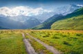 Old country road in Caucasus mountains. Majestic summer view of Shkhara peak, Ushguli location, Georgia