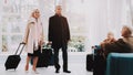 Old Couple with Bags in Airport in Waiting Room.