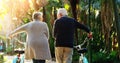 Old couple, bicycle and forest park with exercise in retirement or rear view, walking or mobility. Man, woman and bike