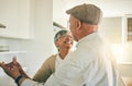 Old couple, dancing in kitchen and happiness with retirement, life partner and love with romance at home together