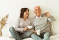 Old couple drinking coffee and taking selfie photos with smartphone. Royalty Free Stock Photo