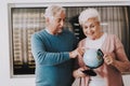 Old Couple with Globe in Airport in Waiting Room.