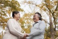 Old couple holding hands and smiling in park Royalty Free Stock Photo