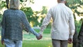 Old couple holding hands and walking in park, romantic date, love and trust Royalty Free Stock Photo