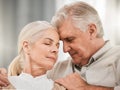 Old couple, hug and forehead touch, relax on sofa with love and support, bonding while at home with trust and comfort Royalty Free Stock Photo