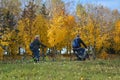 Old couple riding on a bikes on a rural road autumn landscape in the Minsk city Belarus Royalty Free Stock Photo