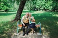 Old couple is sitting on bench in the green park. Grandmother and grandfather at their golden wedding anniversary celebration. Royalty Free Stock Photo