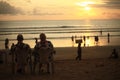 Old couple sitting on chairs enjoying beautiful cloudy sunset at Kuta Beach, Bali, Indonesia Royalty Free Stock Photo