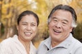 Old couple smiling and looking at camera in park Royalty Free Stock Photo