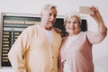 Old Couple Taking Photo in Airport in Waiting Room