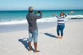 Old couple taking photos at the beach Royalty Free Stock Photo