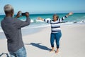 Old couple taking photos at the beach Royalty Free Stock Photo