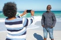 Old couple taking photos at the beach Royalty Free Stock Photo