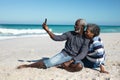 Old couple taking photos at the beach Royalty Free Stock Photo