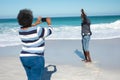 Old couple taking photos at the beach Royalty Free Stock Photo