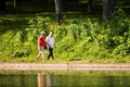 Old couple walking hand in hand near the pond in Park La Fontaine Royalty Free Stock Photo