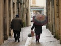 Old couple walking under the rain