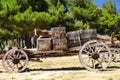 An old covered wagon wheel. Traditional wooden tumbrel, wooden crates loaded