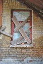 Old covered windows in abandoned old brick house