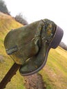 Old cowboy boot on fencepost in an agricultural area Royalty Free Stock Photo