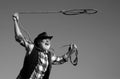 Old cowboy with lasso rope at ranch or rodeo. Bearded western man with brown jacket and hat catching horse or cow. Royalty Free Stock Photo