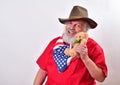 Old cowboy shows his love with his teddy bear and patriotic bandana Royalty Free Stock Photo