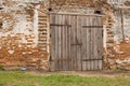 Old cowshed. Large wooden gate and dried wood. Old brick building Royalty Free Stock Photo