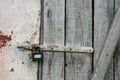 Old, cracked barn door. Gray color, crumbling wall with padlock