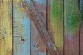 Old cracked boards with peeling and cracks, randomly painted in different colors: yellow, blue, green Royalty Free Stock Photo