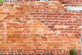 Old cracked brick wall of a building with cement joints on a bright sunny day. Wallpaper. Background Royalty Free Stock Photo