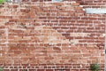 Old cracked brick wall of a building with cement joints on a bright sunny day. Wallpaper. Background Royalty Free Stock Photo