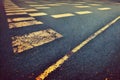 Old cracked textured asphalt road with traffic marking rough abstract background. Aged grainy urban roadway with stripe