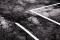 Old cracked textured asphalt road with traffic marking rough abstract background. Aged grainy urban roadway with stripe