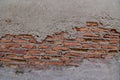 The Old Cracked Wall of a concrete building. A part of the red brick wall was abandoned wall background Royalty Free Stock Photo