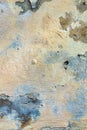 Old cracked weathered painted wall background texture. Light peeled plaster wall with falling off flakes of paint Royalty Free Stock Photo