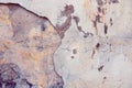 Old cracked weathered painted wall background texture. Light peeled plaster wall with falling off flakes of paint Royalty Free Stock Photo