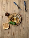 Old cracked wooden round board with lunch on an old kitchen wooden table. Scrambled eggs, broccoli and fried chicken breast pieces Royalty Free Stock Photo