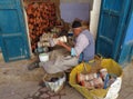 An old craftsman wrapping leather around miniature ceramic drums