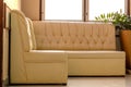 Old cream-colored sofa in the corner of the room with window light Royalty Free Stock Photo