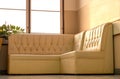 Old cream-colored sofa in the corner of the room with window light Royalty Free Stock Photo