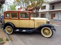 Old cream 1930s Ford Model A Fordor sedan three window parked in