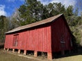 Old creepy abandoned building in rural Georgia corner view red barn on bricks Royalty Free Stock Photo