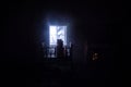 Old creepy eerie baby crib near window in dark room. Scary baby silhouette in dark. A realistic dollhouse living room with