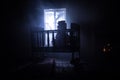 Old creepy eerie baby crib near window in dark room. Scary baby silhouette in dark. A realistic dollhouse living room with