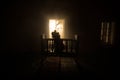 Old creepy eerie baby crib near window in dark room. Scary baby silhouette in dark. A realistic dollhouse living room with Royalty Free Stock Photo
