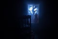 Old creepy eerie baby crib near window in dark room. Scary baby silhouette in dark. A realistic dollhouse living room with