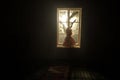 Old creepy eerie baby crib near window in dark room. Scary baby silhouette in dark. A realistic dollhouse living room with