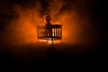 Old creepy eerie wooden baby crib in dark toned foggy background. Horror concept. Scary baby and bed silhouette in dark